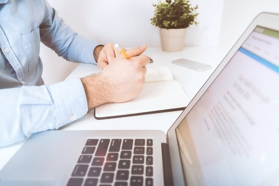 A man taking notes at a laptop